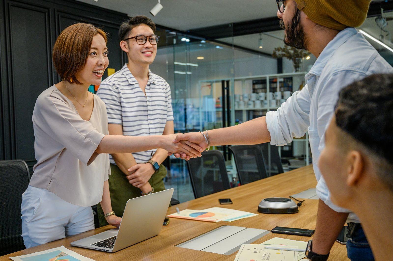 Friendly team welcoming a new client with a handshake